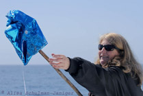 Nancy Black collecting a mylar balloon from the ocean